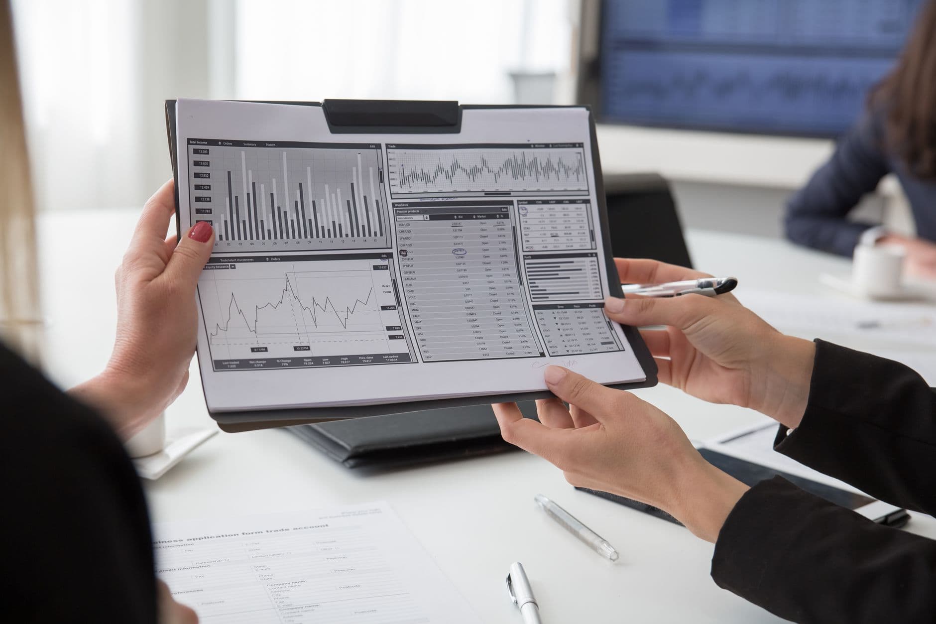 Professionals reviewing data charts on paper during a business meeting.