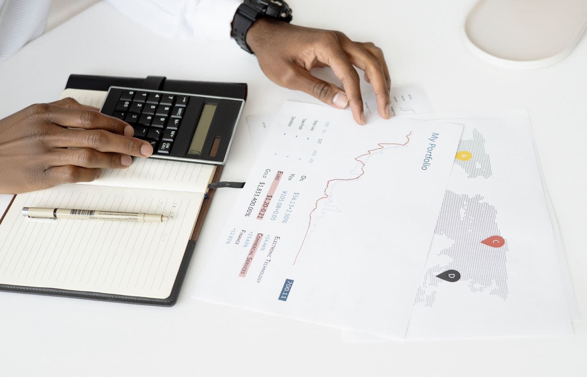 Overhead view of a person analyzing financial documents using a calculator for investment planning.
